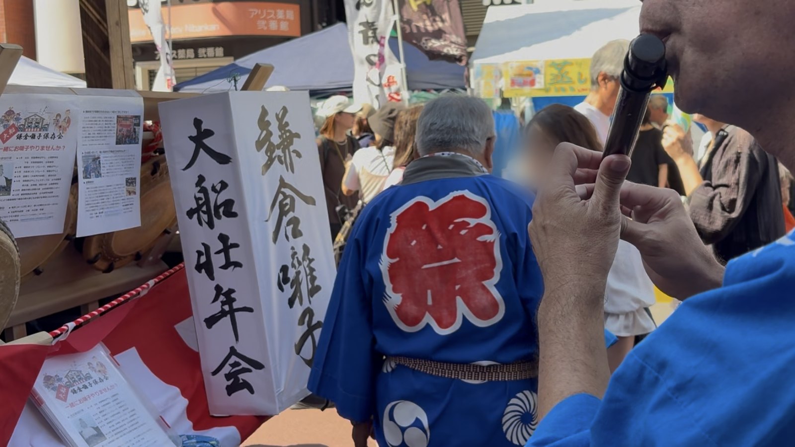祭りでお囃子の篠笛を吹く様子、「祭」の法被と太鼓